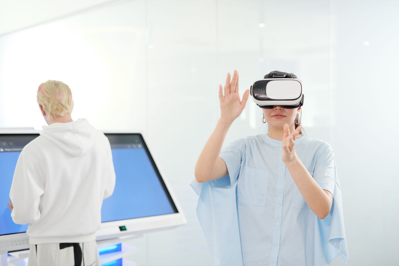 Woman exploring virtual reality with VR goggles in a modern technological environment.